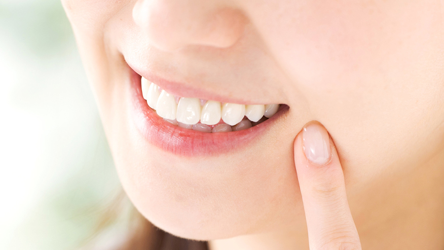 前歯の歯並びを確認する女性患者