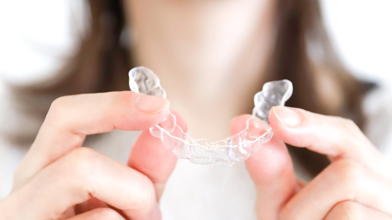 後戻りを防ぐため、リテーナーを装着する様子